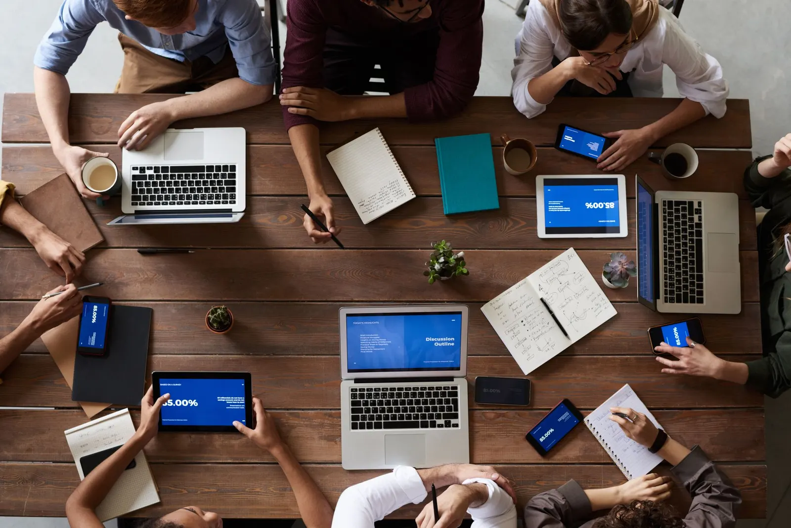 Team plant an einem Tisch mit Laptops und Notizen eine Online-Marketing-Kampagne