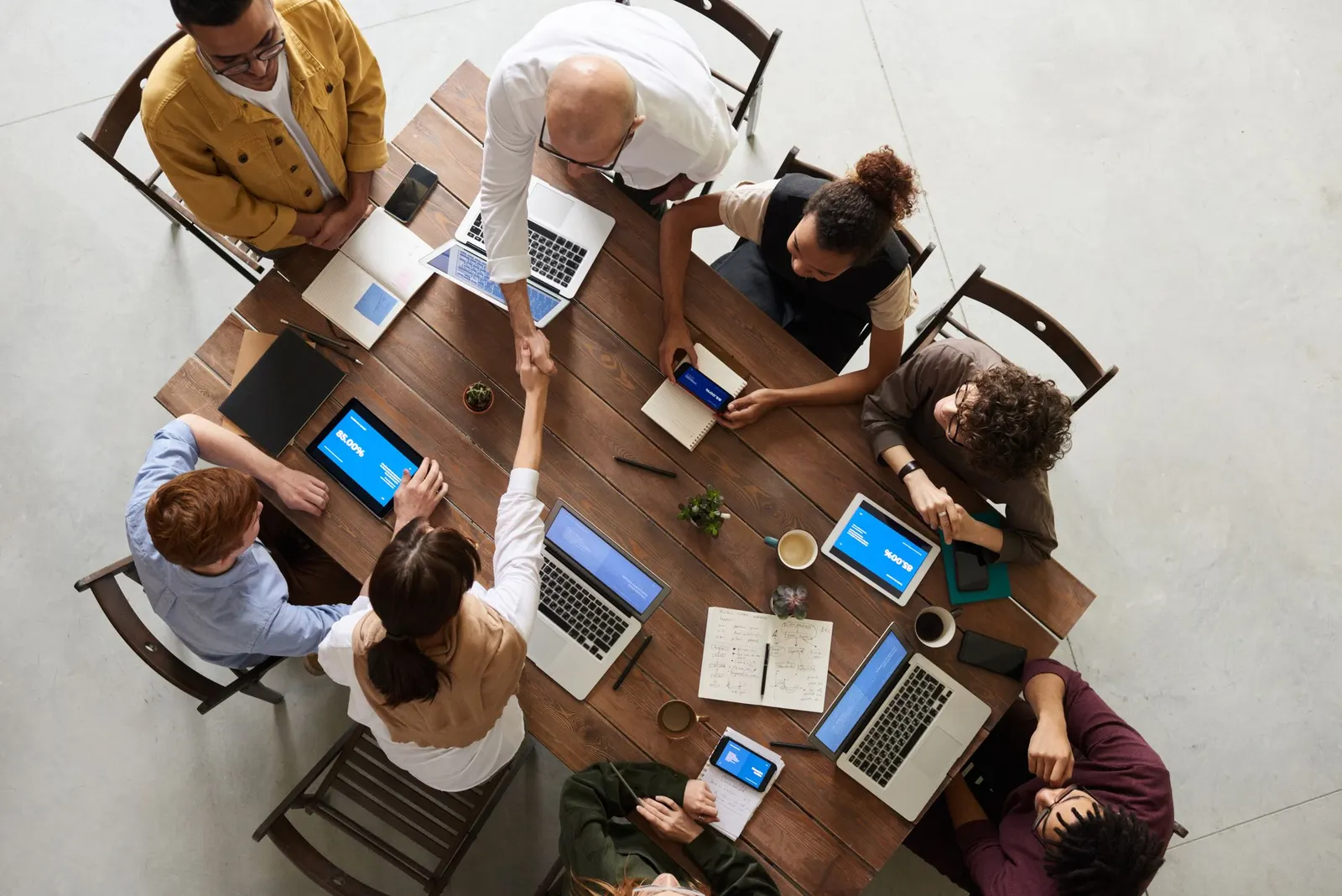 Team arbeitet an einem Tisch mit Laptops und Tablets zusammen
