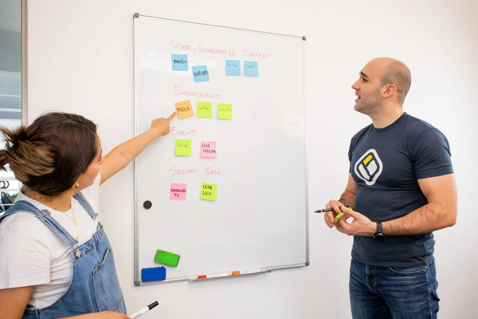 Zwei Personen planen an einem Whiteboard mit Haftnotizen einen Relaunch